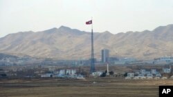 FILE - North Korea's flag flies on a tower high above the village of Ki Jong Dong, as seen from Observation Post Ouellette in the Demilitarized Zone, DMZ, the tense military border between the two Koreas, in Panmunjom, March 25, 2012. (AP Photo/Susan Walsh, File)