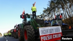 Polish farmers block the A2 motorway as they stand atop a tractor, to protest over price pressures, taxes and against the import of agricultural products from Ukraine, close to the Polish-German border, Feb. 25, 2024. 