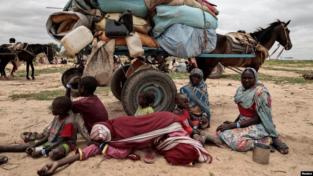 Sudanese family who fled the conflict in Murnei in Sudan's Darfur region, sit beside their belongings while waiting to be registered by UNHCR upon crossing the border between Sudan and Chad in Adre, Chad, July 26 , 2023.