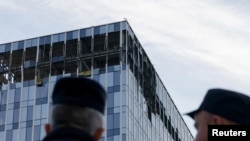 24일 러시아 수도 모스크바 시내에 무인항공기(드론) 공격이 단행된 것으로 알려진 가운데, 보안 당국 관계자들이 파손된 건물 주변을 지키고 있다. 