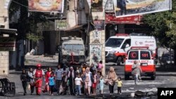 Warga kamp pengungsi Jenin di Tepi Barat yang diduduki melarikan diri saat berlangsungnya operasi militer Israel, 4 Juli 2023. (RONALDO SCHEMIDT/AFP)