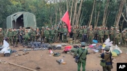 FILE - Members of the Myanmar National Democratic Alliance Army pose for a photograph with the weapons allegedly seized from the Myanmar's army outpost on a hill in Chinshwehaw town, Myanmar, Oct. 28, 2023.