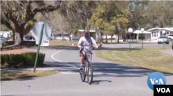 A man rides a bike at the Hawthorne at Leesburg retirement community in Florida, Feb. 27, 2023.