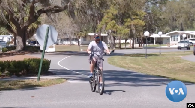 A man rides a bike at the Hawthorne at Leesburg retirement community in Florida, Feb. 27, 2023.