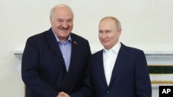 FILE - Russian President Vladimir Putin, right, and Belarusian President Alexander Lukashenko shake hands during a meeting in St. Petersburg, Russia, July 23, 2023. (Alexander Demianchuk, Sputnik, Kremlin pool photo via AP)