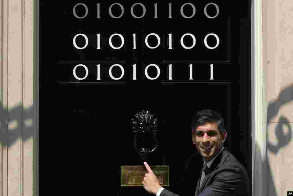 Britain&#39;s Prime Minister Rishi Sunak poses by the door of 10 Downing Street, which is adorned with the numbers one and zero that in binary code represent London Tech Week in London.