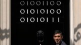 Britain's Prime Minister Rishi Sunak poses by the door of 10 Downing street which is adorned with the numbers one and zero that in binary code represent London Tech Week in London, June 14, 2023. 