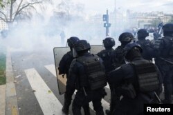 French riot police stand in position during clashes at a demonstration as part of the 10th day of nationwide strikes and protests against French government's pension reform in Paris, France, March 28, 2023.