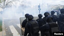 French riot police stand in position during clashes at a demonstration as part of the 10th day of nationwide strikes and protests against French government's pension reform in Paris, France, March 28, 2023.