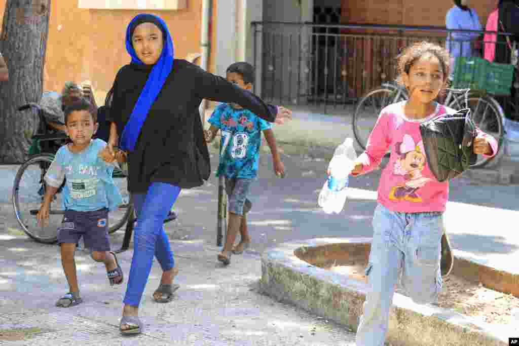Palestinian residents flee their home after clashes that erupted between members of the Palestinian Fateh group and Islamist militants in the Palestinian refugee camp of Ein el-Hilweh near the southern port city of Sidon, Lebanon.