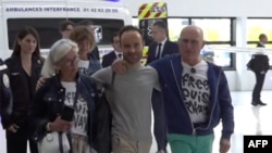 This grab taken from pool video footage made available by LCI television network shows French citizen Louis Arnaud flanked by his mother and father upon arrival at Le Bourget airport, north of Paris, June 13, 2024. 