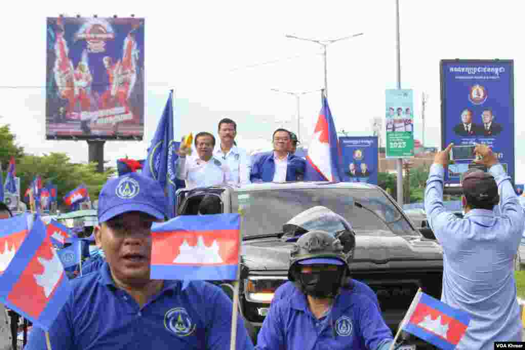 លោក យ៉ែម បុញ្ញប្ញទ្ធិ (ឆ្វេង) និង លោក ញឹក ប៊ុនឆៃ (ស្តាំ) ដឹកនាំ​អ្នកគាំទ្រ​គណបក្សគណបក្ស​ខ្មែរ​រួប​រួម​ជាតិរបស់ខ្លូន​នៅការហែក្បួនយុទ្ធនាការឃោសនាបោះឆ្តោតនៅរាជធានី​ភ្នំពេញ ថ្ងៃទី១ ខែកក្កដា ឆ្នាំ២០២៣។ (លាស់ លីបលីប/វីអូអេ)