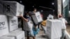 Para pekerja memuat kotak suara ke dalam truk untuk didistribusikan ke TPS menjelang pemilu di Medan, Sumatra Utara, 12 Februari 2024. (Foto: AP)