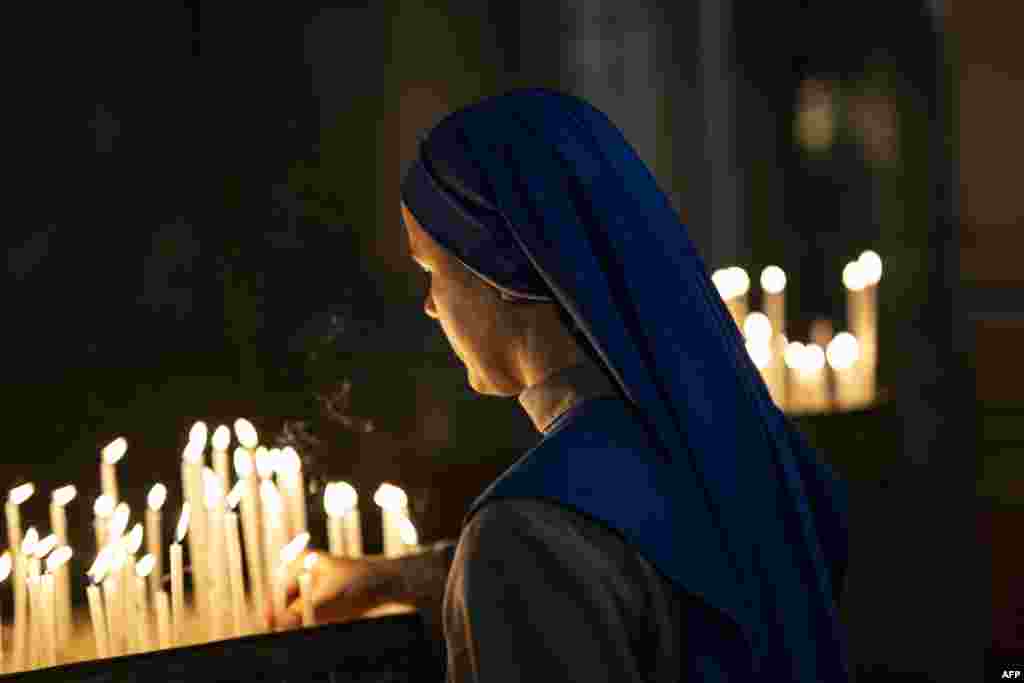 A worshipper lights candles as she attends a Christmas Mass at the Catholic Cathedral of the Holy Spirit at the Beyoglu district of Istanbul on December 24, 2023.&nbsp;