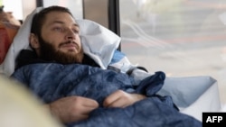 Wounded Ukrainian soldier Vladyslav Shakhov is taken off the plane in an elevator upon arrival at Berlin Brandenburg airport having been transported in a medical evacuation (Medevac) airplane from Poland, on March 23, 2023.
