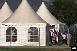 In this image taken from video, refugees from the first group of about 30 people from Nagorno-Karabakh gather in a temporary camp after arriving to Kornidzor village in Syunik region, Armenia, Sept. 24, 2023.