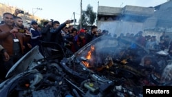 Palestinians react at the site of an Israeli strike on a car, amid the ongoing conflict between Israel and the Palestinian Islamist group Hamas, in Rafah, in the southern Gaza Strip, Feb. 7, 2024.