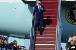 President Joe Biden waves as he walks down the steps of Air Force One at Vilnius International Airport in Vilnius, Lithuania, July 10, 2023.