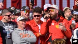 Kansas City Chiefs tight end Travis Kelce, right, serenades the crowd, as Patrick Mahomes, second from right, and teammates look on at the Chiefs' Super Bowl victory rally in Kansas City, Mo., Feb. 14, 2024.