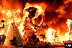 FILE - Ninots (cardboard figurines) in a 'falla' (a huge ornate cardboard sculpture made to eventually be burnt) burn on the last night of the Fallas Festival in Valencia, Spain, March 19, 2023. (Photo by JOSE JORDAN / AFP)