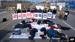 South Korean activists stage a die-in during a rally to demand the peace on the Korean peninsula near the Unification Bridge, which leads to the Panmunjom in the Demilitarized Zone in Paju, South Korea, Feb. 2, 2024.