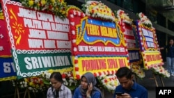 Karangan bunga yang menyatakan keprihatinan para penggemar sepak bola di luar kantor Persatuan Sepak Bola Indonesia di Jakarta, 30 Maret 2023. (BAY ISMOYO / AFP)