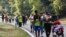 Migrants walk on the side of the highway through Villa Comaltitlan, Chiapas state, southern Mexico, Dec. 27, 2023, as they make their way north to the U.S. border. 