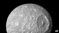 This Feb. 13, 2010 image provided by NASA shows Saturn's moon Mimas and it's large Herschel Crater, captured by the Cassini spacecraft. (NASA/JPL-Caltech/Space Science Institute via AP)