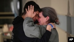 This handout photo provided by Haim Zach/GPO shows Sharon Hertzman, right, hugging a relative as they reunite at Sheba Medical Center in Ramat Gan, Israel, Nov. 25, 2023. 
