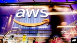 Seorang pengunjung tampak berjalan melewati tempat konferensi yang digelar oleh Amazon Web Services di Las Vegas, pada 30 November 2022. (Foto: Noah Berger/Amazon Web Services via AP Images)