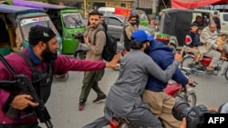 Police personnel detain supporters of the Pakistan Tehreek-e-Insaf (PTI) party during a protest in Peshawar, Jan. 28, 2024.