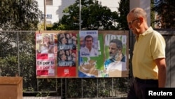 FILE - FILE PHOTO: A man walks past electoral posters ahead of the July 23 snap election, in Ronda, Spain, July 7, 2023. 