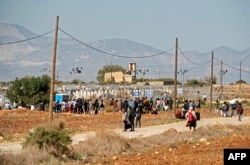 Para migran meninggalkan kamp Pournara di Kokkinotrimithia, pinggiran ibu kota Nicosia, setelah dilaporkan terjadi kerusuhan di fasilitas tersebut, 28 Oktober 2022. (Iakovos Hatzistavrou/AFP)