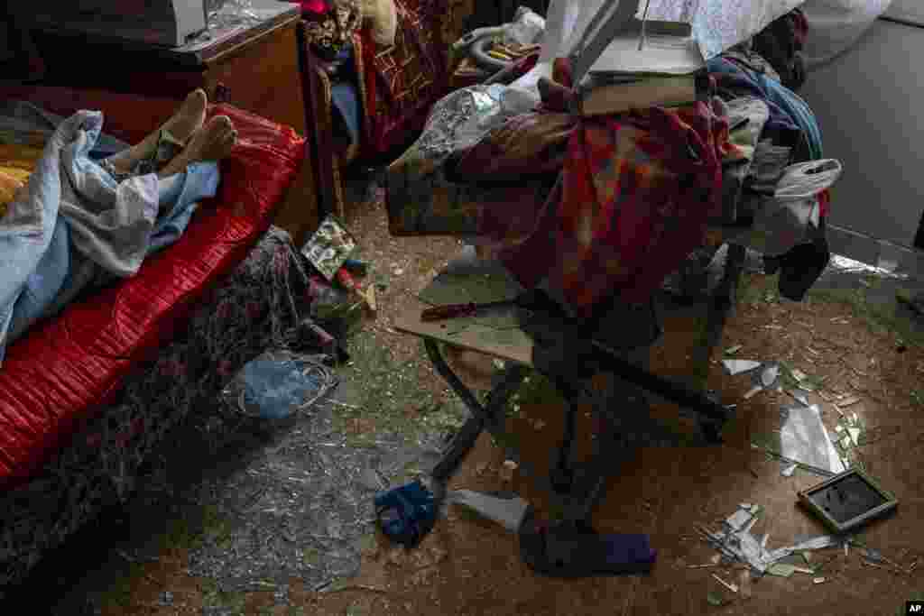 El cadáver de una mujer que falleció durante un ataque a Uman, en el centro de Ucrania, yace sobre una cama, el 28 de abril de 2023. (AP Foto/Bernat Armangue).