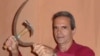 Jorge Fernández Era, escritor cubano, posa en su casa de La Habana, Cuba con una hoz y un martillo en una franca alusión al símbolo del comunismo, en una imagen para un post satírico en Facebook. [Foto cortesía del entrevistado].