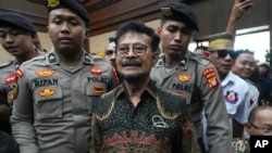 Former Indonesian Agriculture Minister Syahrul Yasin Limpo, center, is escorted by police officers upon arrival for his sentencing hearing on a corruption case at the Corruption Court in Jakarta, Indonesia, July 11, 2024. 