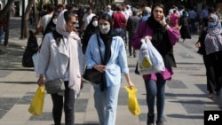 Women shop in the old main bazaar of Tehran, Iran, Oct. 1, 2022. All women in Iran must wear a veil while in public.