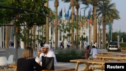 People sit during the United Nations Climate Change Conference (COP28), in Dubai, United Arab Emirates, Dec. 3, 2023. 