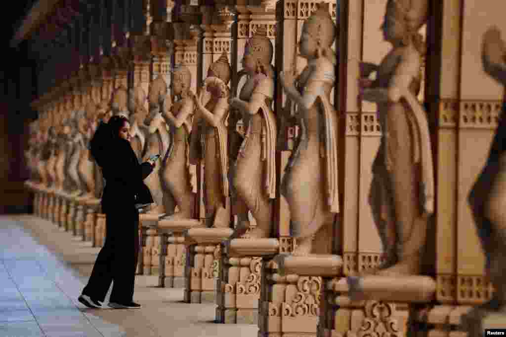 A woman looks at pink sandstone statues during celebrations for Diwali, the Hindu festival of lights, at Akshardham Mahamandir temple in Robbinsville, New Jersey, Nov. 12, 2023.