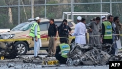 Security personnel gather at the site of the bomb blast in Hayatabad area of Peshawar on July 18, 2023.
