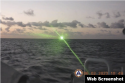 Dalam foto yang dirilis oleh penjaga pantai Filipina ini, sebuah kapal penjaga pantai China menggunakan sinar laser militer, yang secara singkat membutakan awak kapal di kapal patroli Filipina.