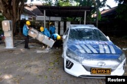 FILE - Petugas menyiapkan unit pengisian kendaraan listrik untuk kendaraan polisi di Nusa Dua, Bali, Indonesia, 29 Oktober 2022. (Antara Foto/Fikri Yusuf via REUTERS)