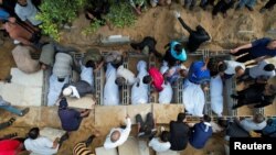 FILE - Para pelayat menguburkan jenazah warga Palestina dari keluarga Zraiee, yang tewas dalam serangan Israel, di sebuah pemakaman di Jalur Gaza tengah, 17 Oktober 2023. (REUTERS/Mohammed Fayq Abu Mostafa)