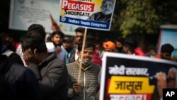 FILE - An opposition Congress party worker holds a placard during a protest accusing Prime Minister Narendra Modi's government of using military-grade spyware to monitor political opponents, journalists and activists, in New Delhi, India, Feb. 2, 2022.