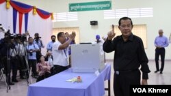 Mantan Perdana Menteri Hun Sen menunjukkan jarinya kepada wartawan usai mencoblos di TPS Provinsi Kandal hari Minggu, 25 Februari 2024.