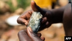 FILE - A Zimbabwean miner holding an ore sample that they found while searching for gold in Kadoma, February 15, 2019
