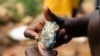 FILE - A Zimbabwean miner holding an ore sample that they found while searching for gold in Kadoma, February 15, 2019.