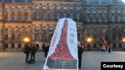 2023年六四周年前夕，荷兰阿姆斯特丹水坝广场前抗议人士展示“国殇之柱”横幅（林生亮提供）