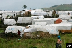 FILE - Shelters are covered in plastic sheets to protect them against the rain at a camp for displaced people, in Bulengo near Goma in eastern Congo, Nov. 18, 2008.