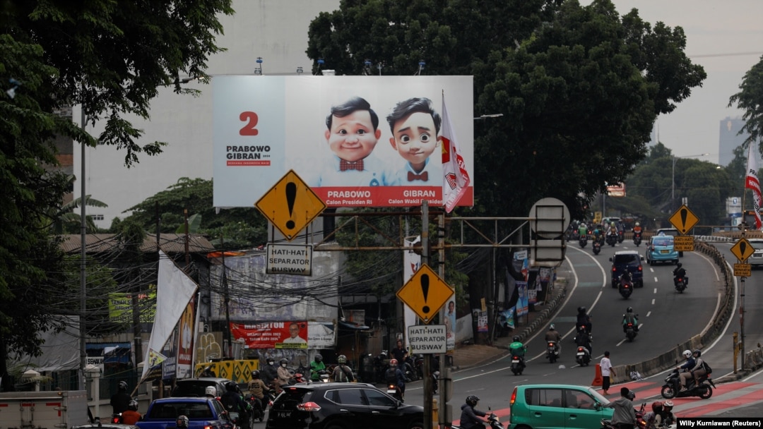 Masyarakat berjalan melewati baliho Menteri Pertahanan dan calon Presiden Prabowo Subianto dan pasangannya Gibran Rakabuming Raka di Jakarta, 12 Januari 2024. (Foto: REUTERS/Willy Kurniawan)